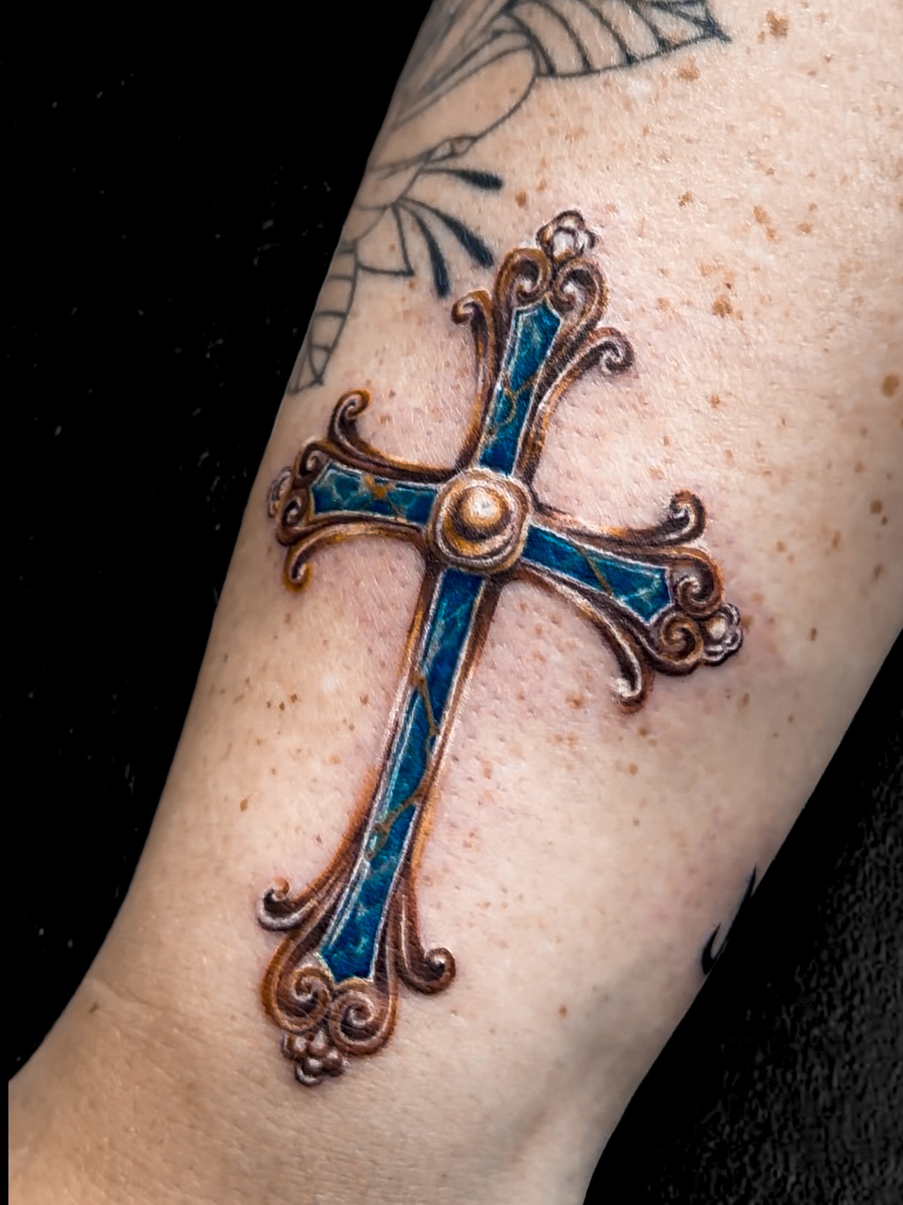 Cross ornamental tattoo on the forearm by Sincere