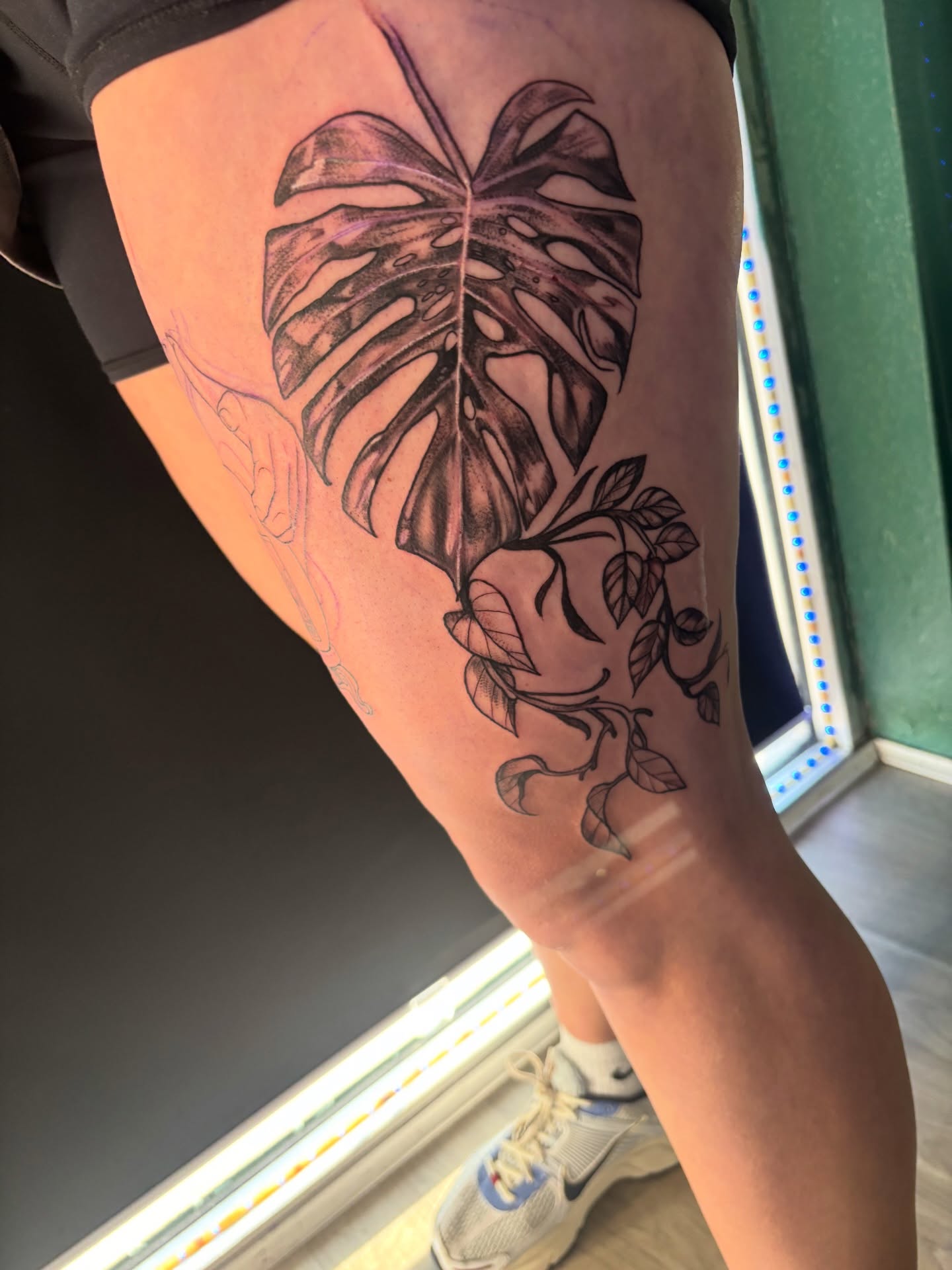 Monstera leaf black and grey tattoo on the thigh by Calen Copeland