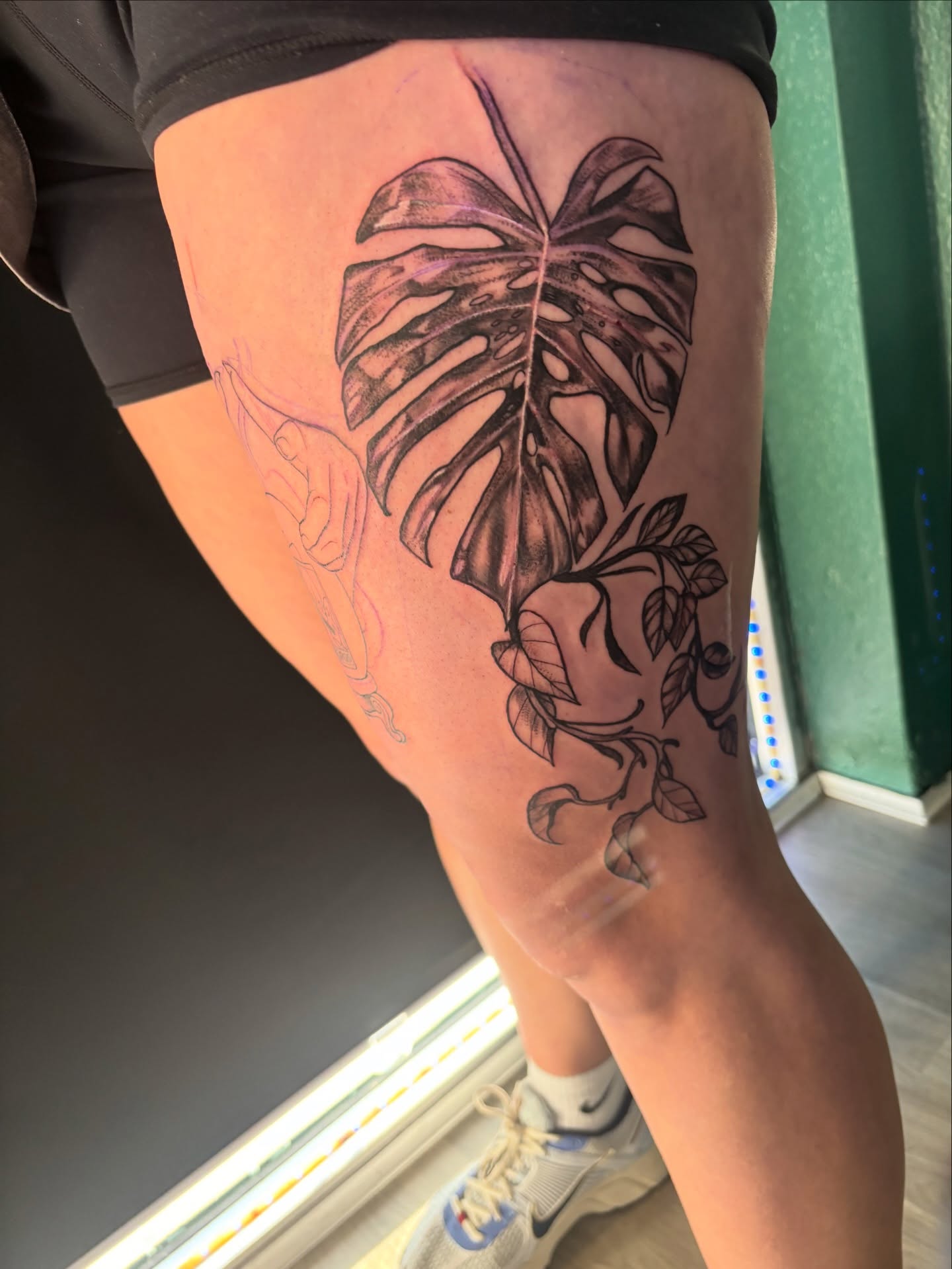 Monstera leaf black and grey tattoo on the thigh by Calen Copeland