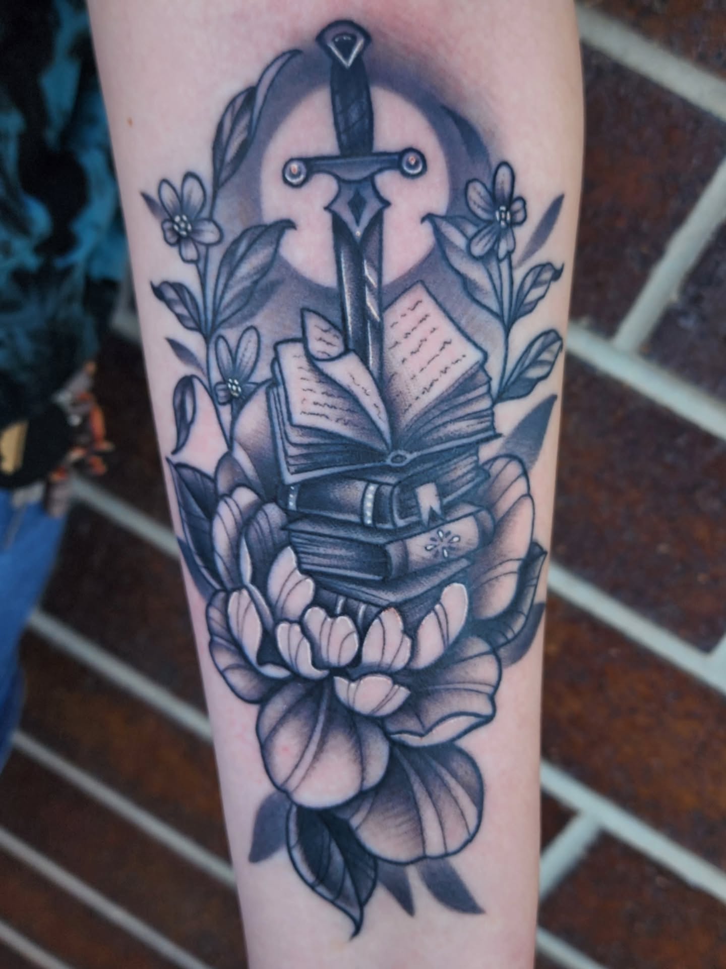 Book and sword American traditional tattoo on the forearm by Shawna Goettsche