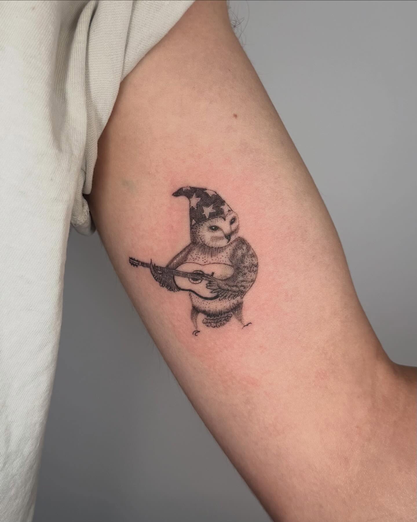 Owl playing guitar dotwork tattoo on the forearm by Felipe Pacifico