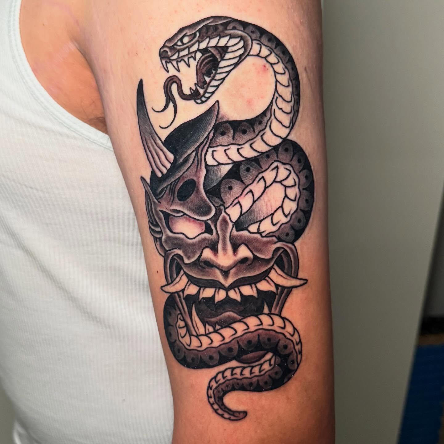 Snake and mask American traditional tattoo on the forearm by Zac Chaffin