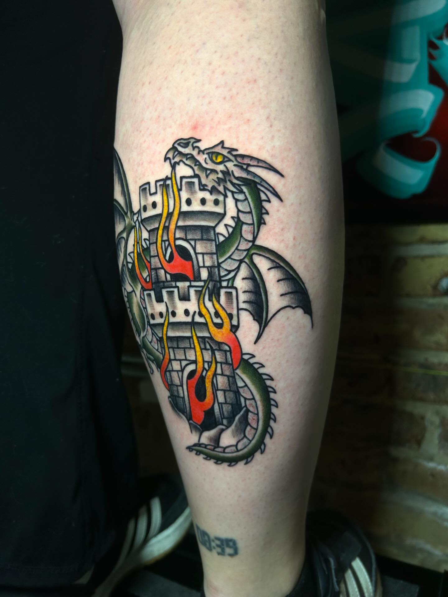 Dragon and castle neo-traditional tattoo on the forearm by Alycia