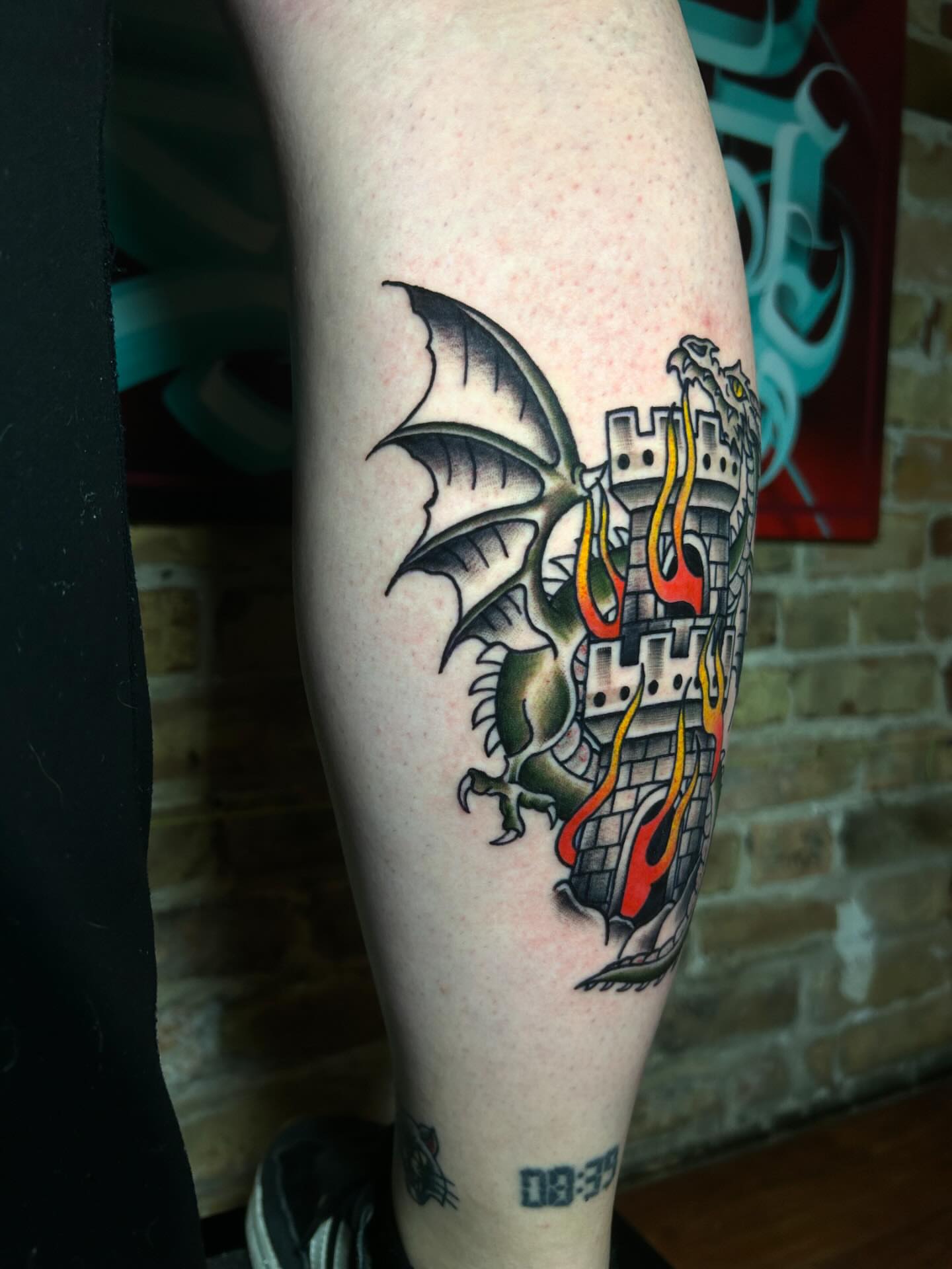 Dragon and castle American traditional tattoo on the forearm by Alycia