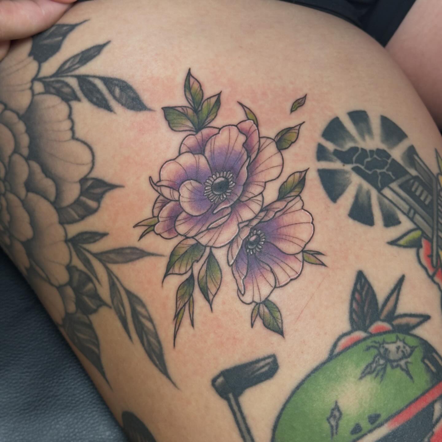 Flowers American traditional tattoo on the thigh by Kerri Colello Sittenauer