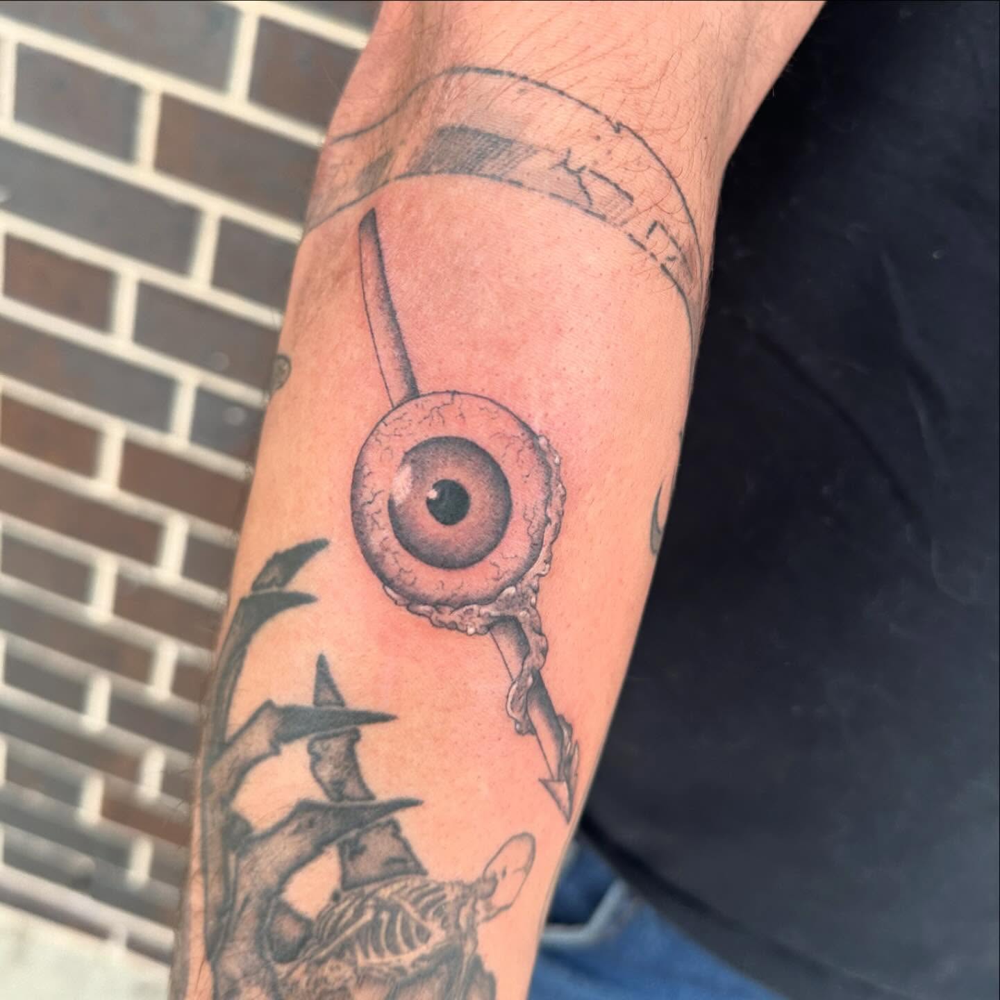 Eye and arrow black and grey tattoo on the forearm by Kerri Colello Sittenauer