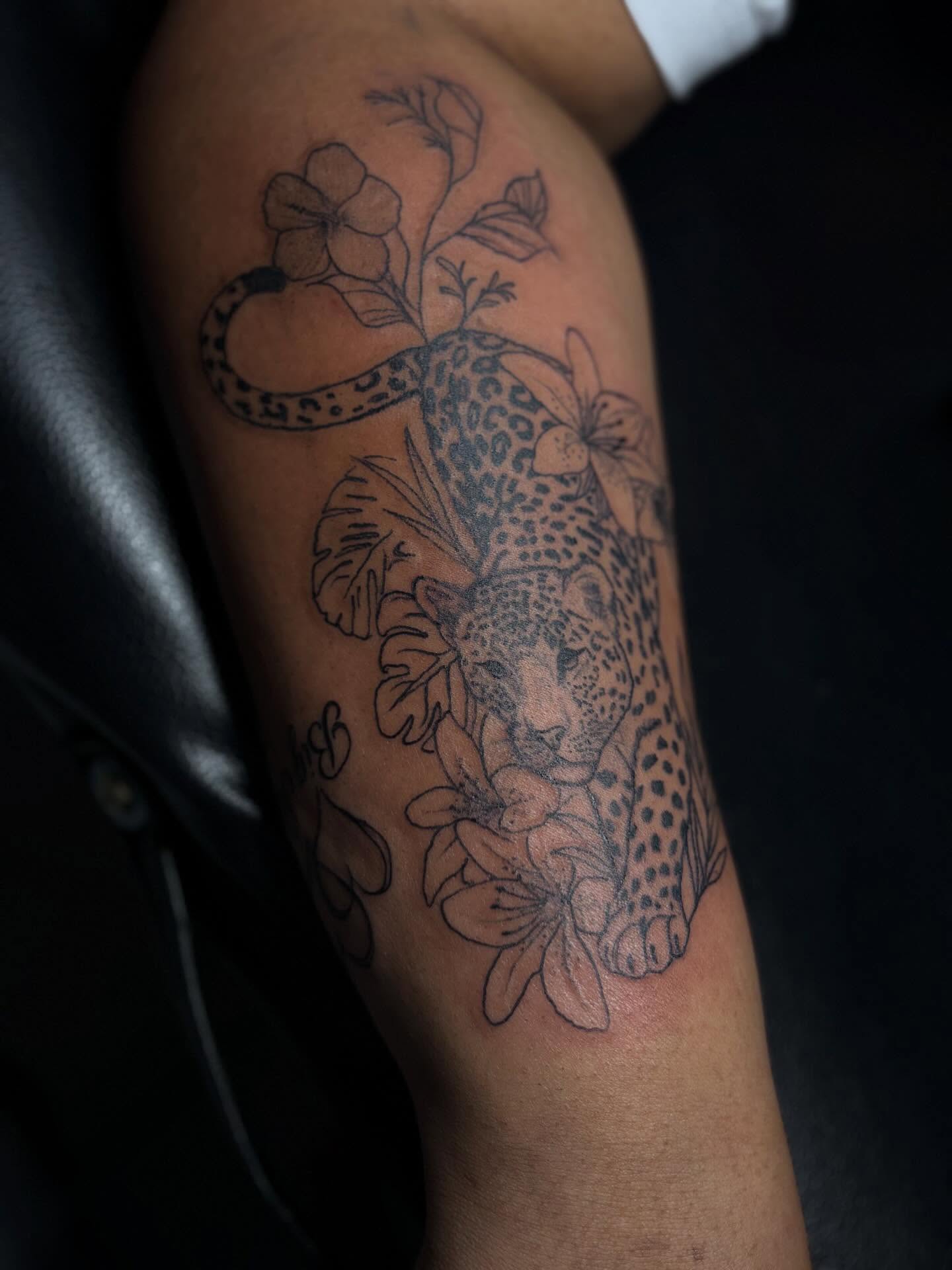 Leopard and flowers black and grey tattoo on the forearm by addicted222inkk🎨