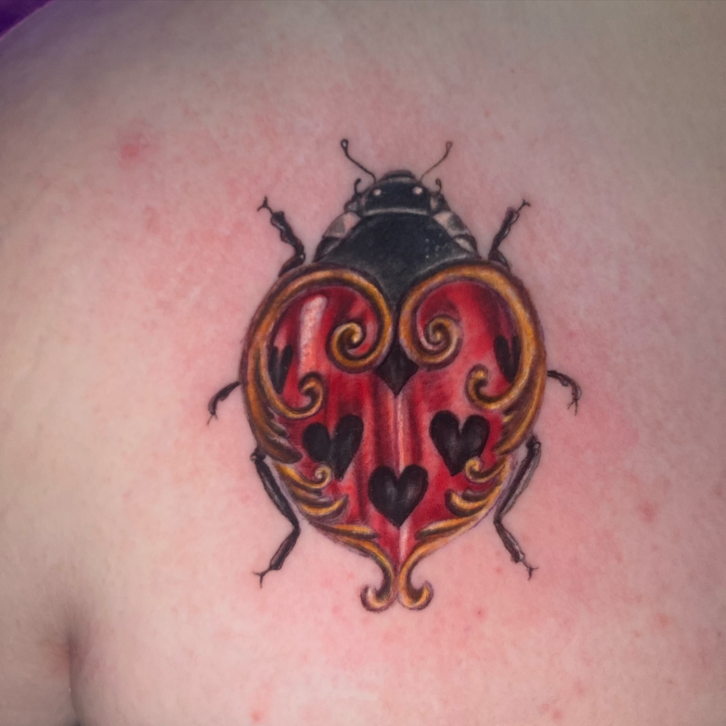 Ladybug realism tattoo on the shoulder by Brittany Whitaker