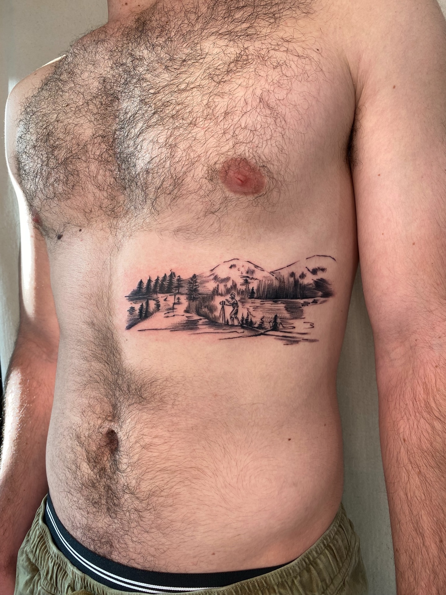 Landscape with figure black and grey tattoo on the chest by Sasha 🪆 Southern California Tattoo Artist
