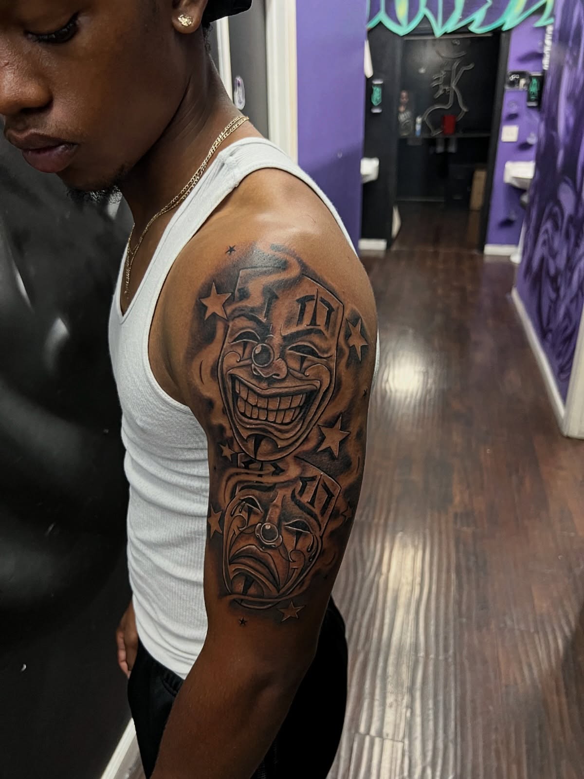 Clown faces black and grey tattoo on the upper arm by @samg_tat2s, San Diego, California