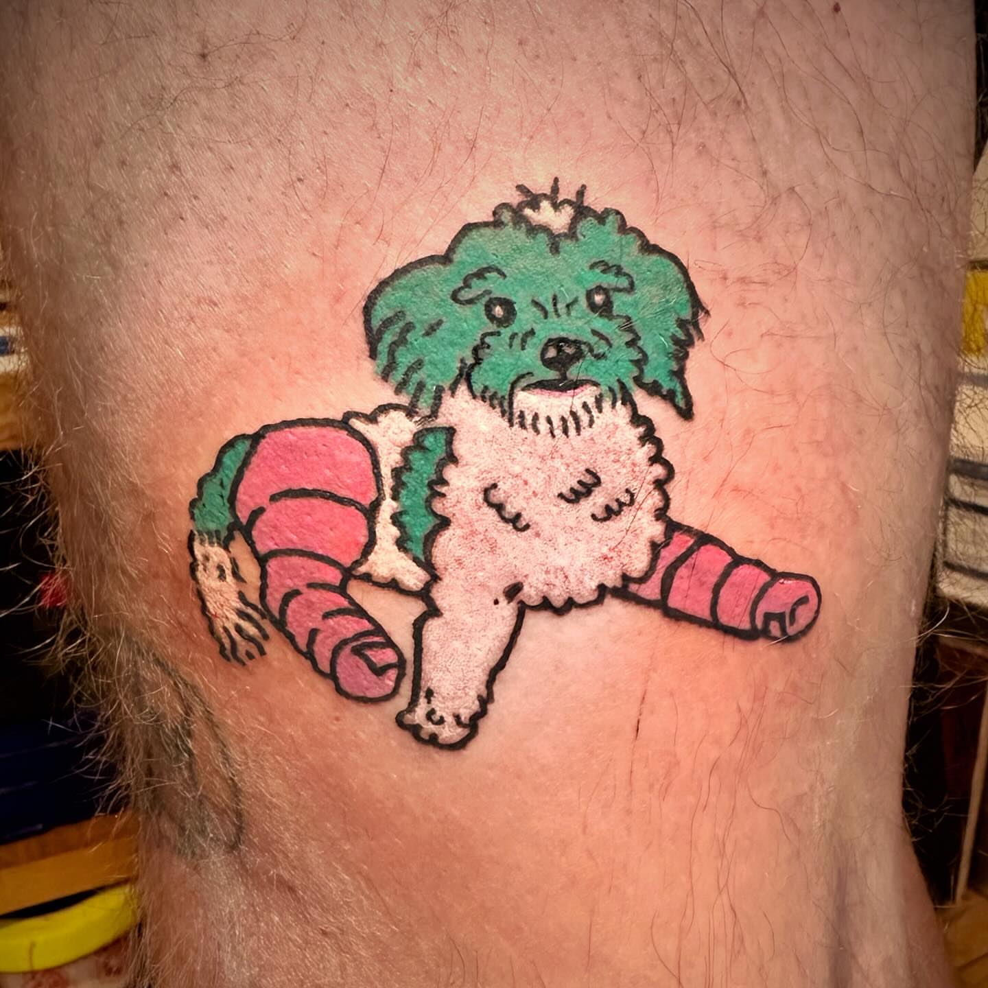Dog wearing pants illustrative tattoo on the thigh by Flash Boom Bang Tattoo