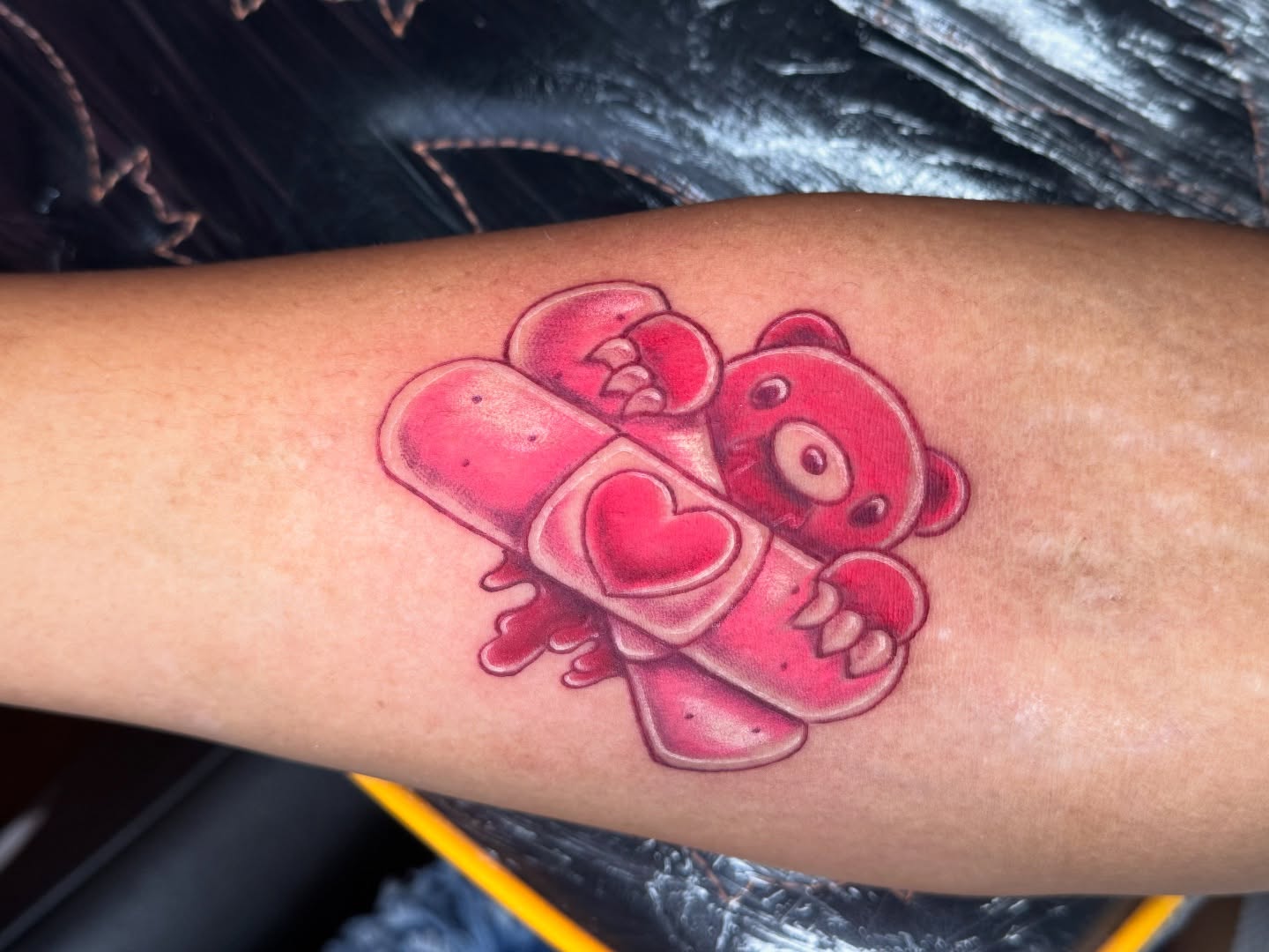 Teddy bear with bandages realism tattoo on the forearm by Breanna B