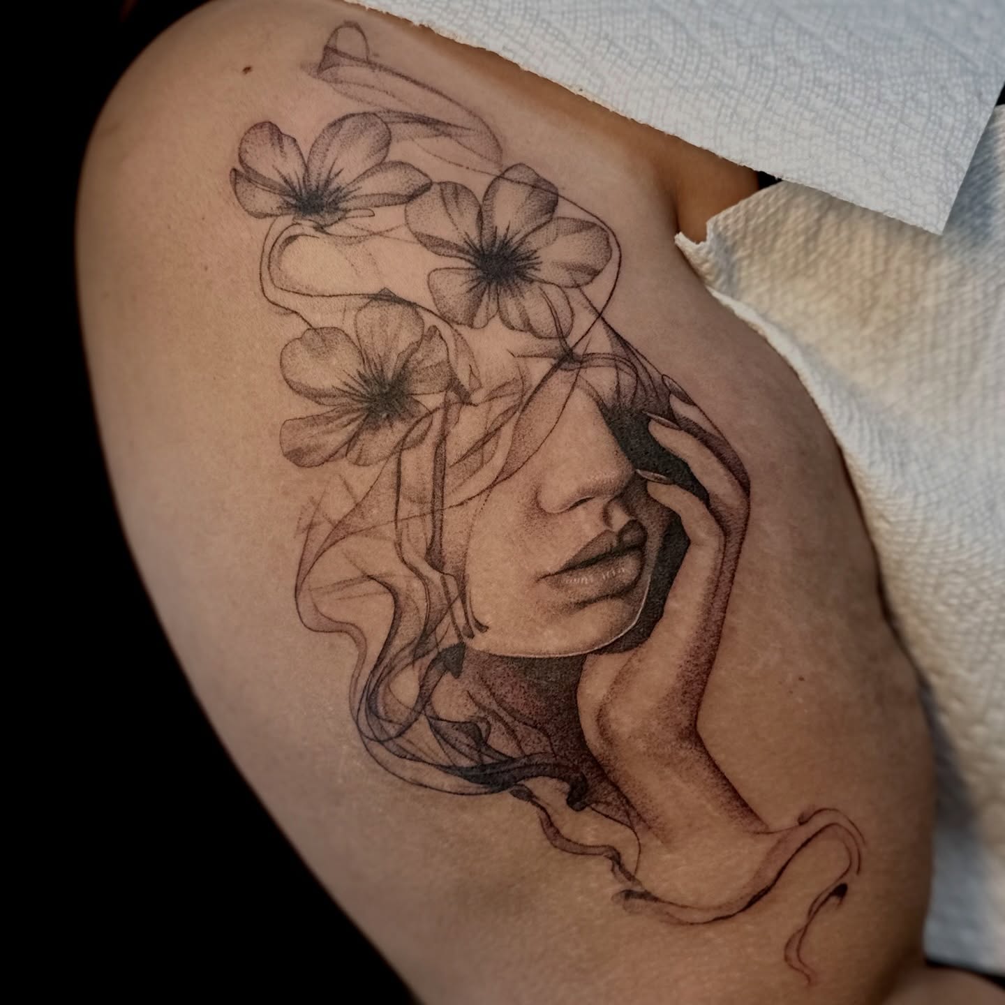 Woman with flowers realism tattoo on the shoulder by Ghost