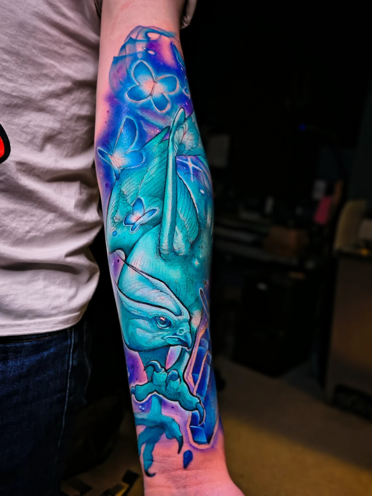 Bird and flowers watercolor tattoo on the forearm by Jorell Elie