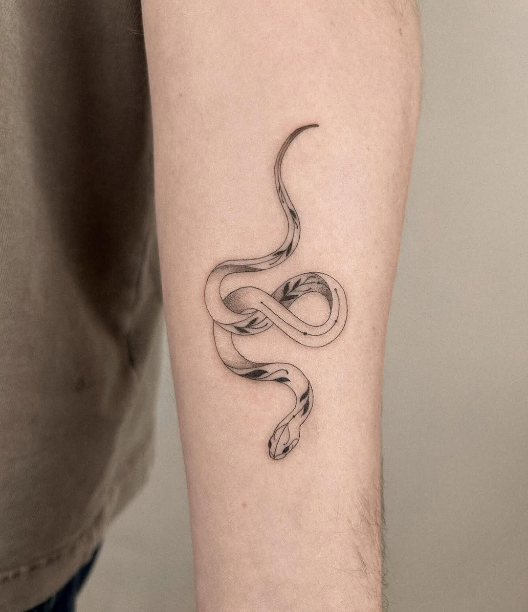 Snake minimalist tattoo on the forearm by Helly March