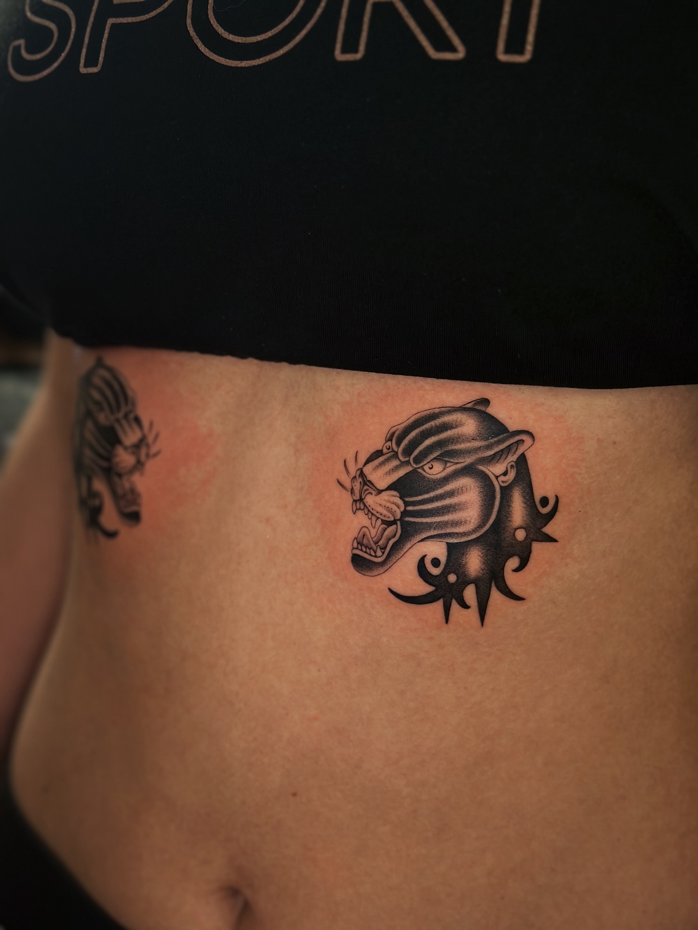Panther head black and grey tattoo on the ribs by Lauryn Jenesis