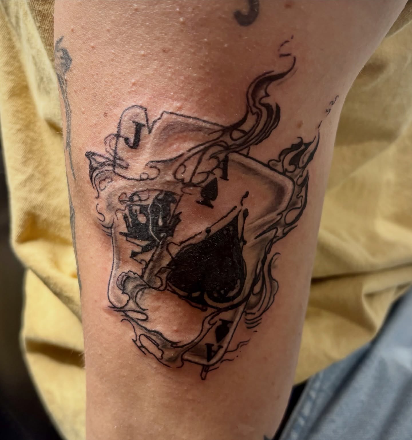 Playing card black and grey tattoo on the forearm by Rayne