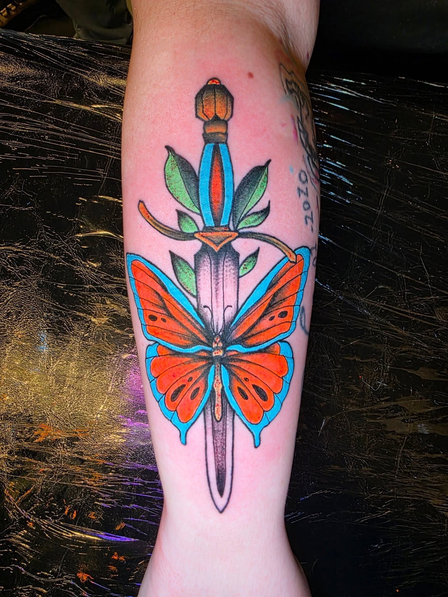 Butterfly and dagger American traditional tattoo on the forearm by Dylan Fowler