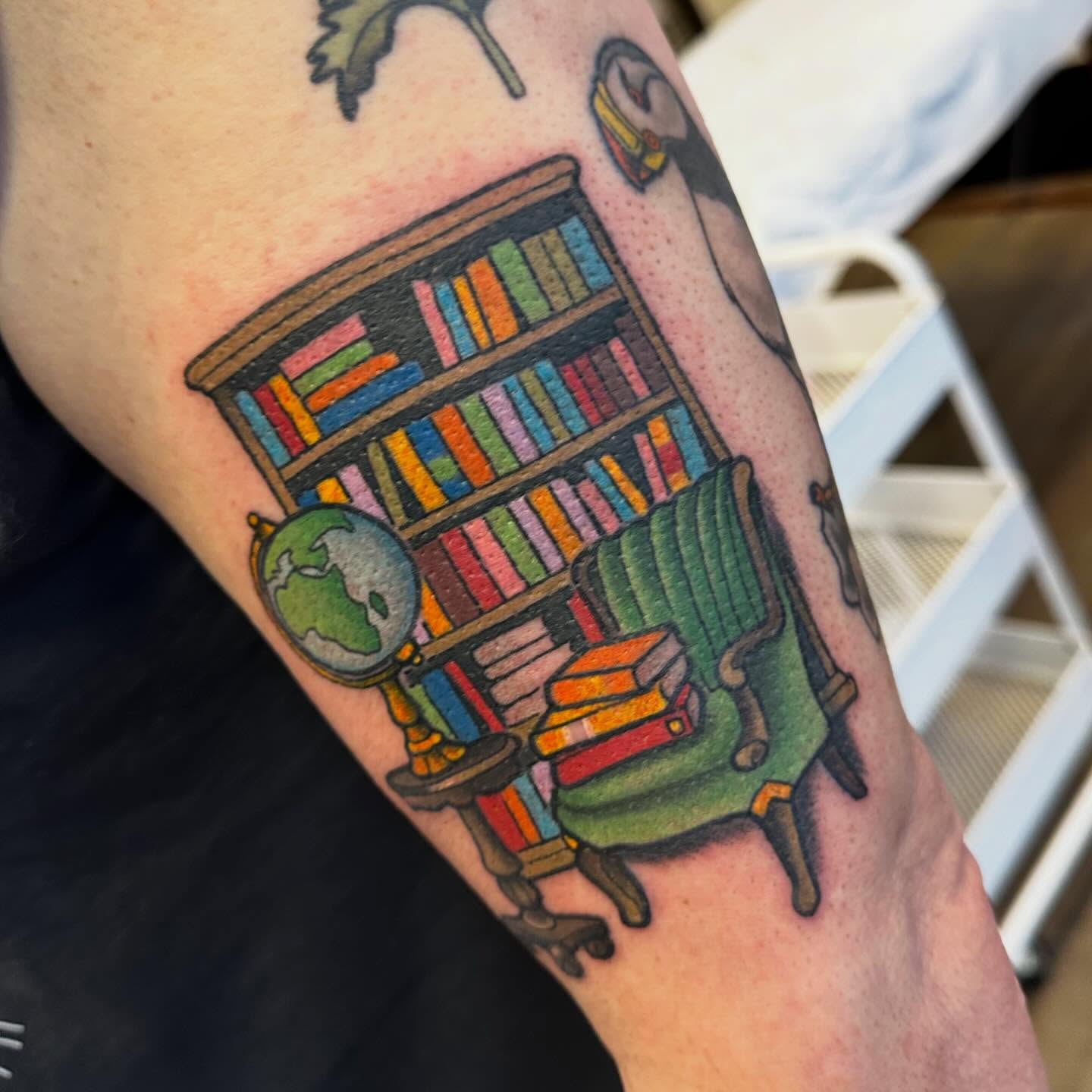 Library scene realism tattoo on the forearm by Katie Beth