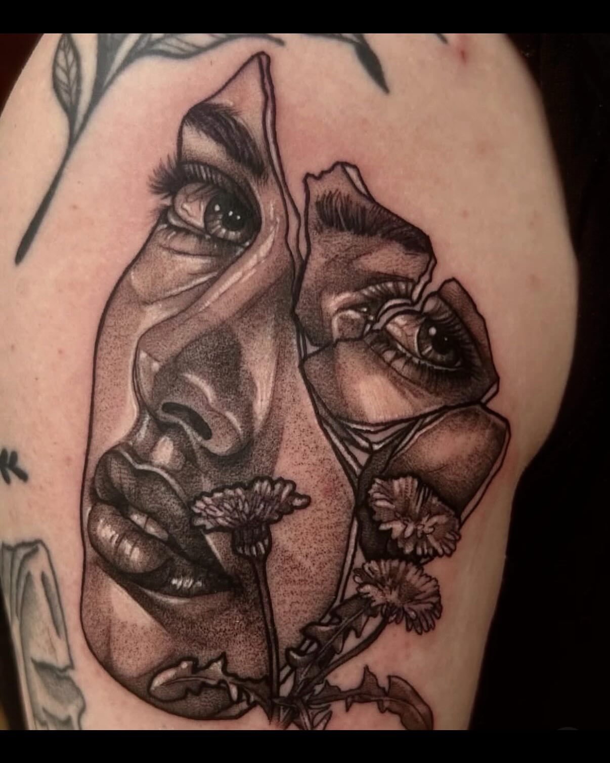 Woman's face with flowers realism tattoo on the upper arm by Emily Falkowski
