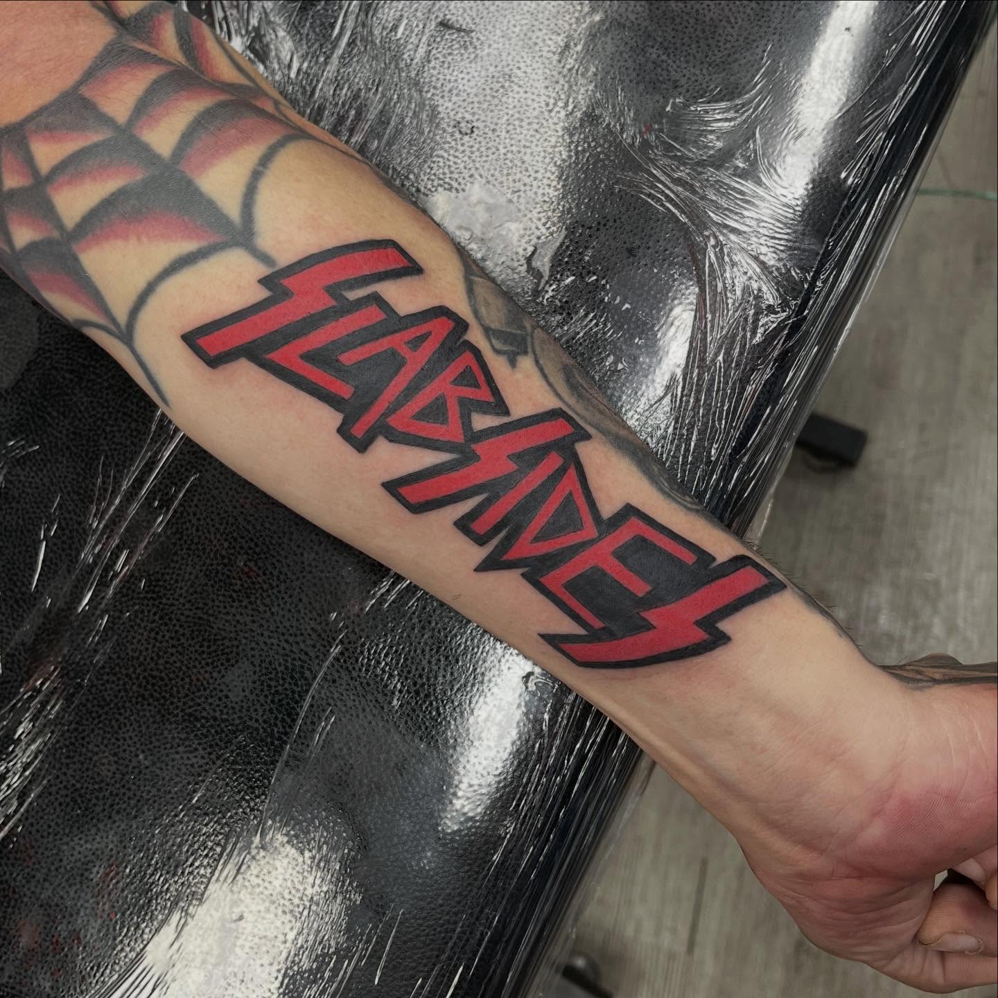 Sabaton lettering script tattoo on the forearm by Franky Sharpz