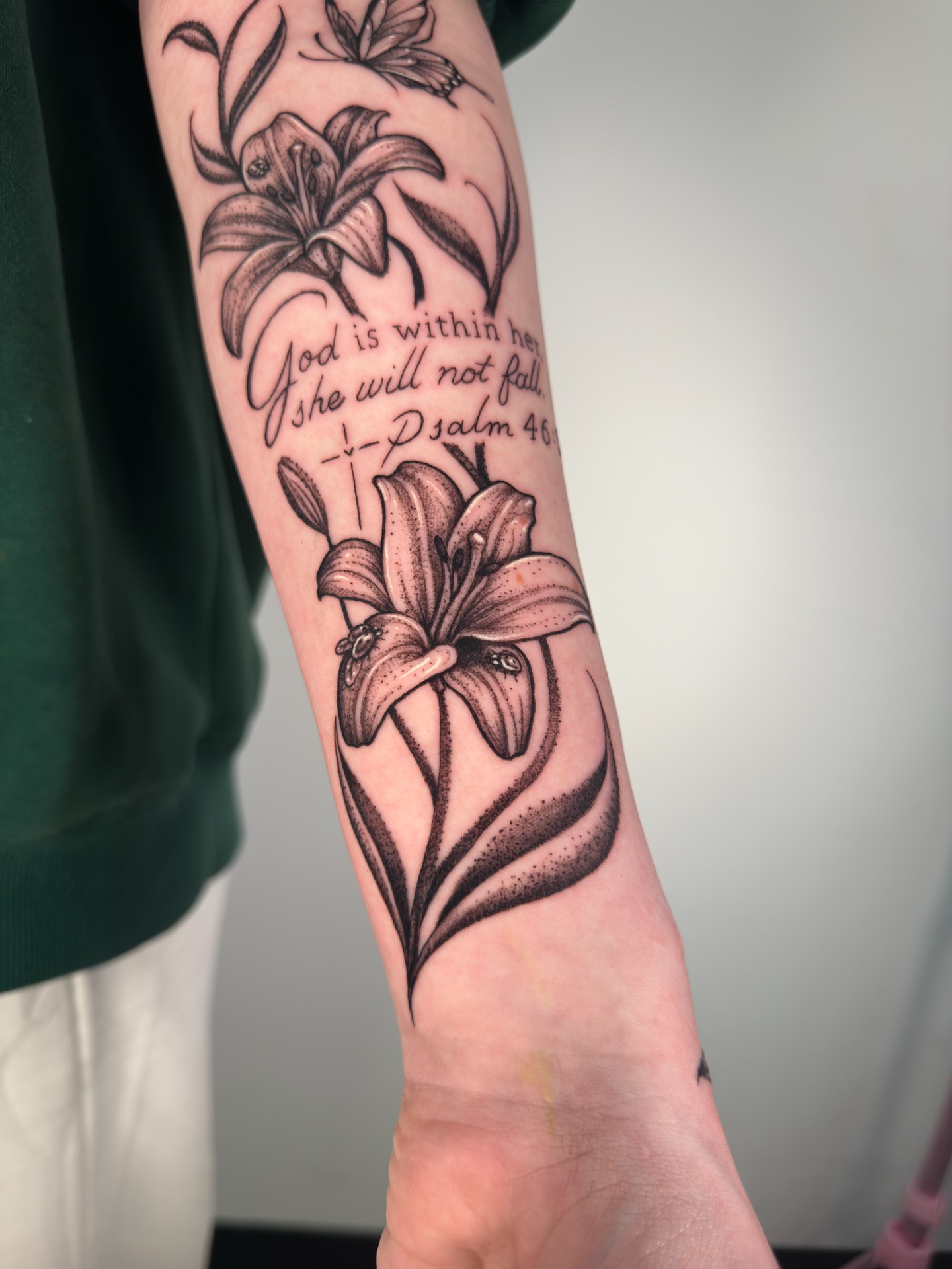 Lilies and scripture black and grey tattoo on the forearm by Diana