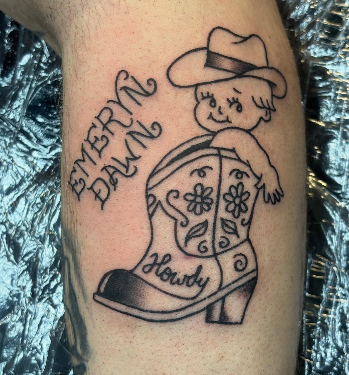 Cowboy boot and child black and grey tattoo on the forearm by Natalie Opal🪻🍎🫖