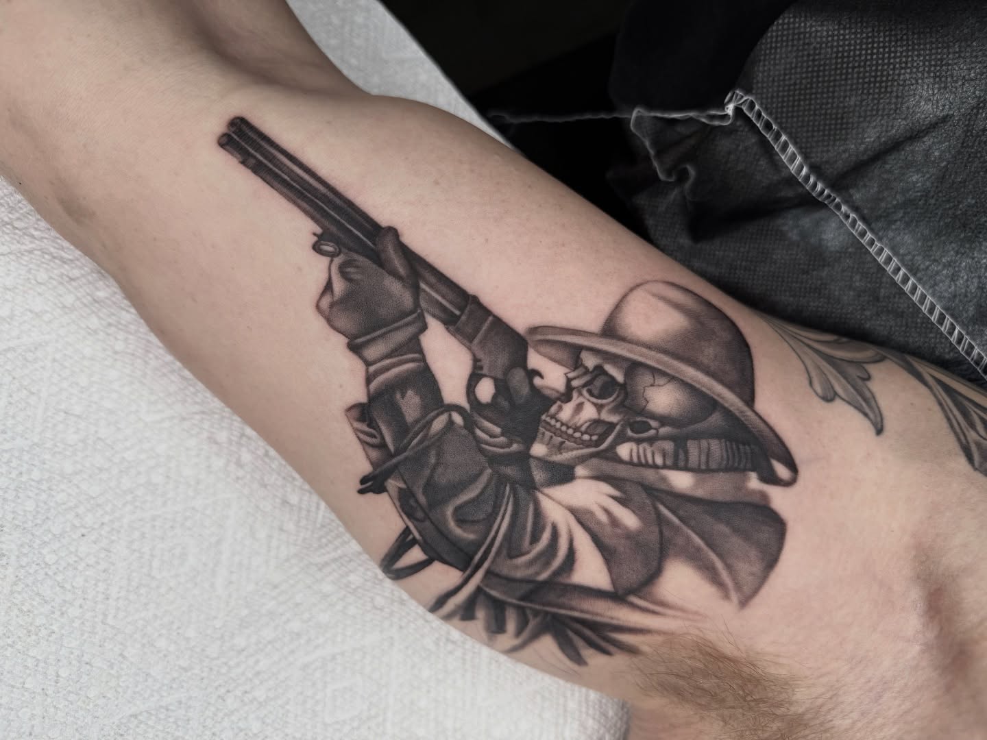 Skull with revolver realism tattoo on the forearm by Joe Weber, Monona, Wisconsin