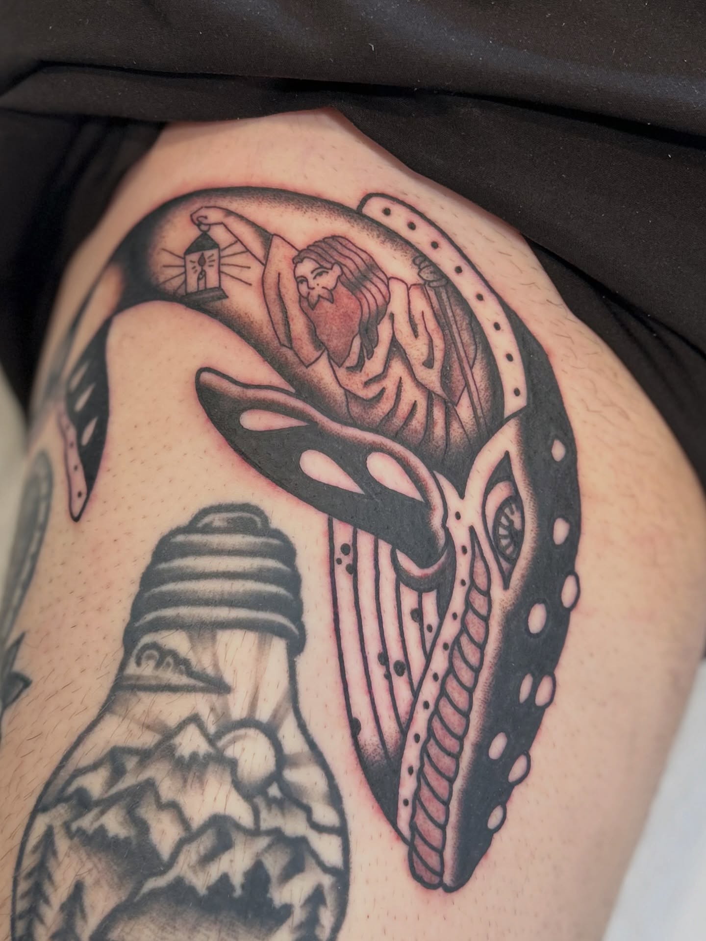 Mask and woman black and grey tattoo on the thigh by Lauren Alexandra