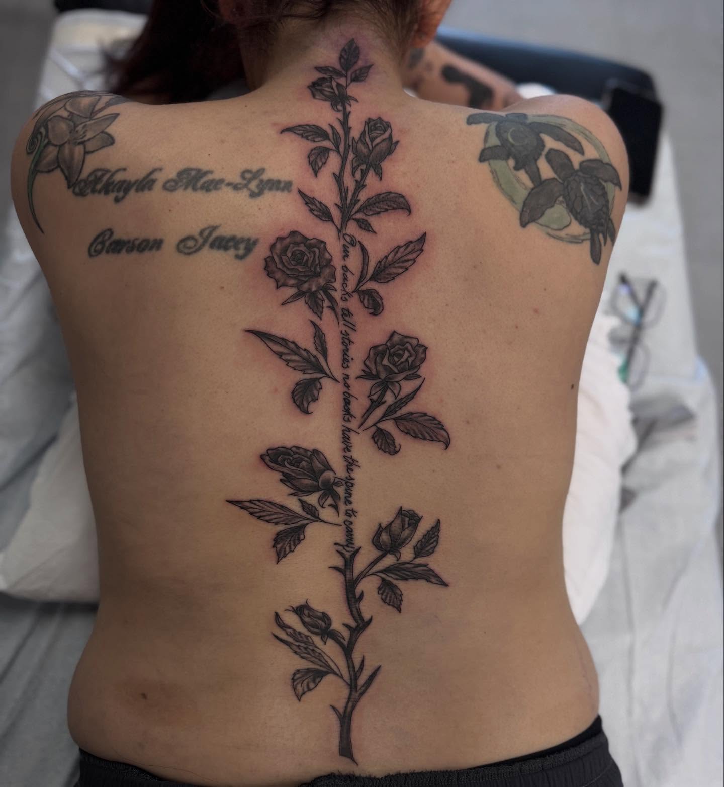 Flower vine black and grey tattoo on the back by Jacob - Tattoo Artist