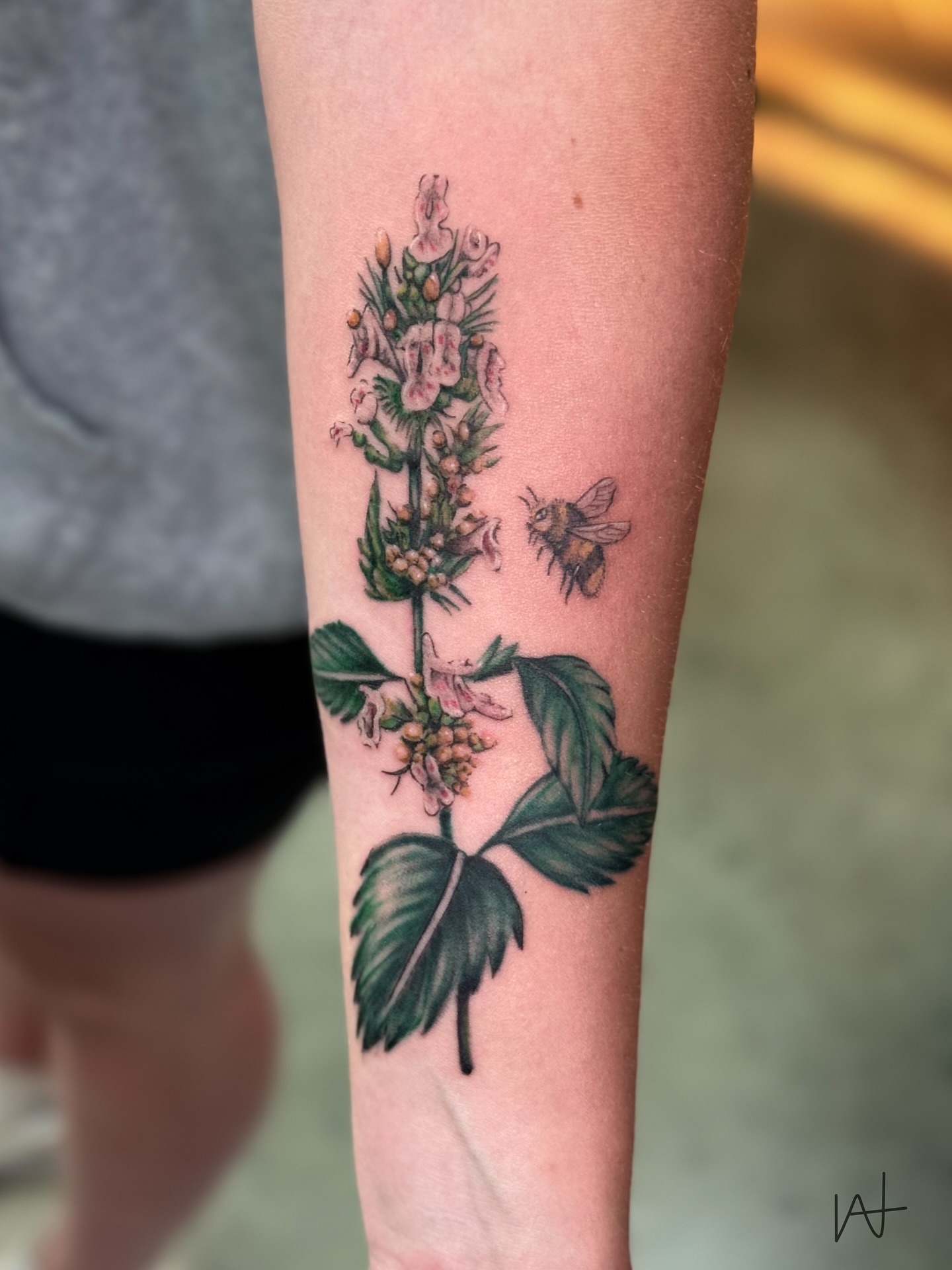 Flower and bee realism tattoo on the forearm by Kat Parmu