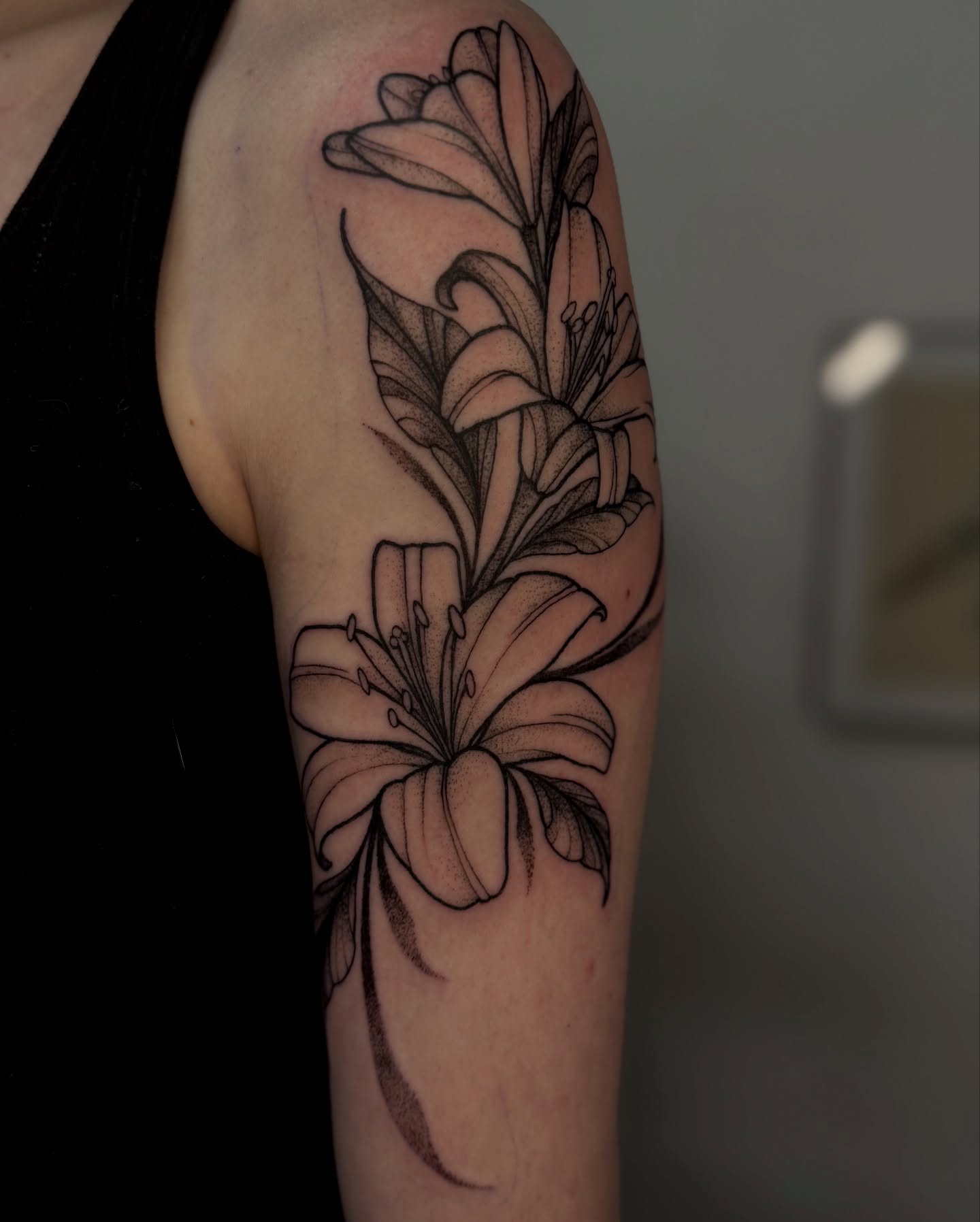Lilies black and grey tattoo on the upper arm by 𝔈𝔩𝔦𝔷𝔞𝔟𝔢𝔱𝔥