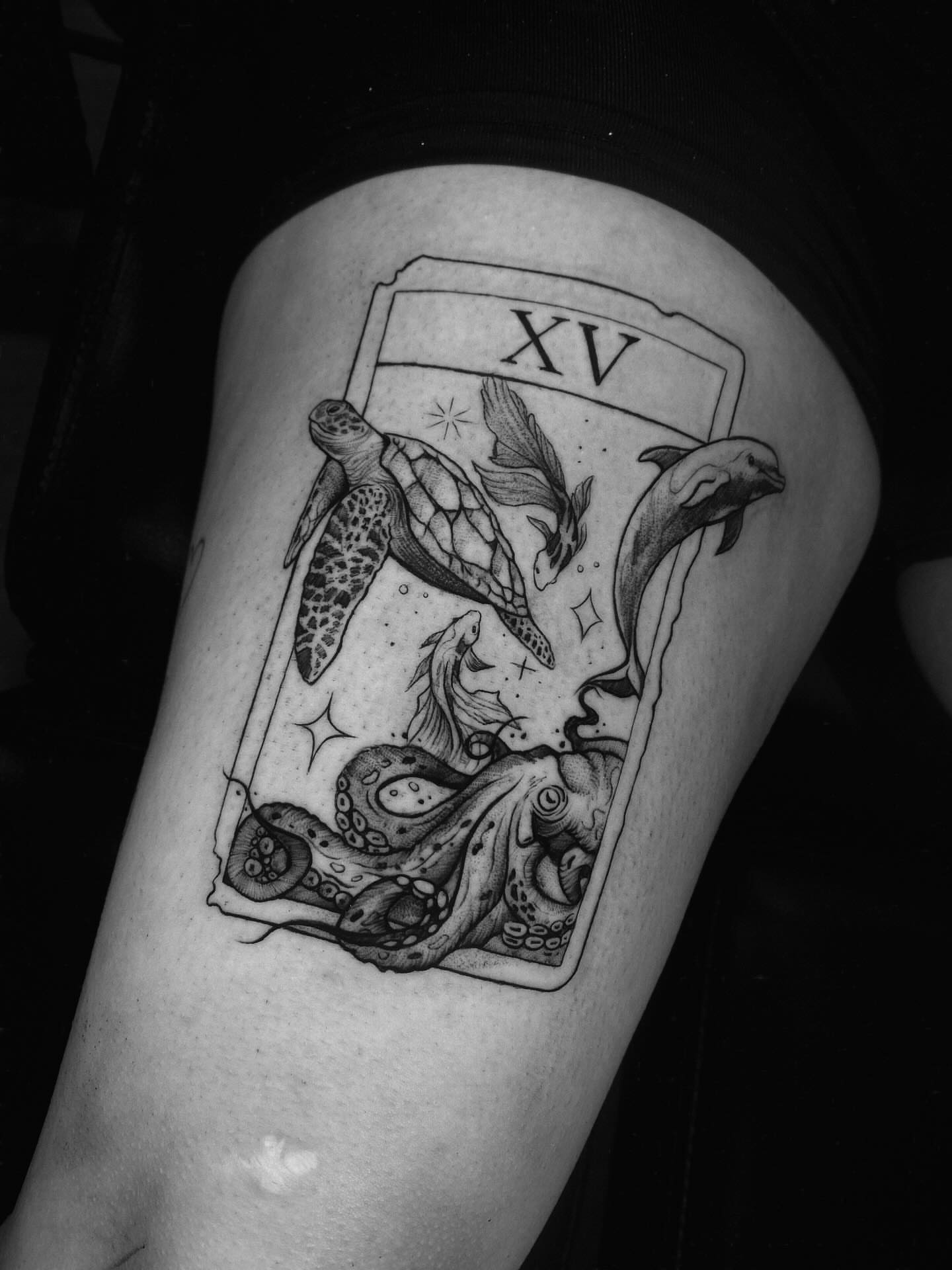 Tarot card with sea creatures realism tattoo on the thigh by Tattoo Medellin