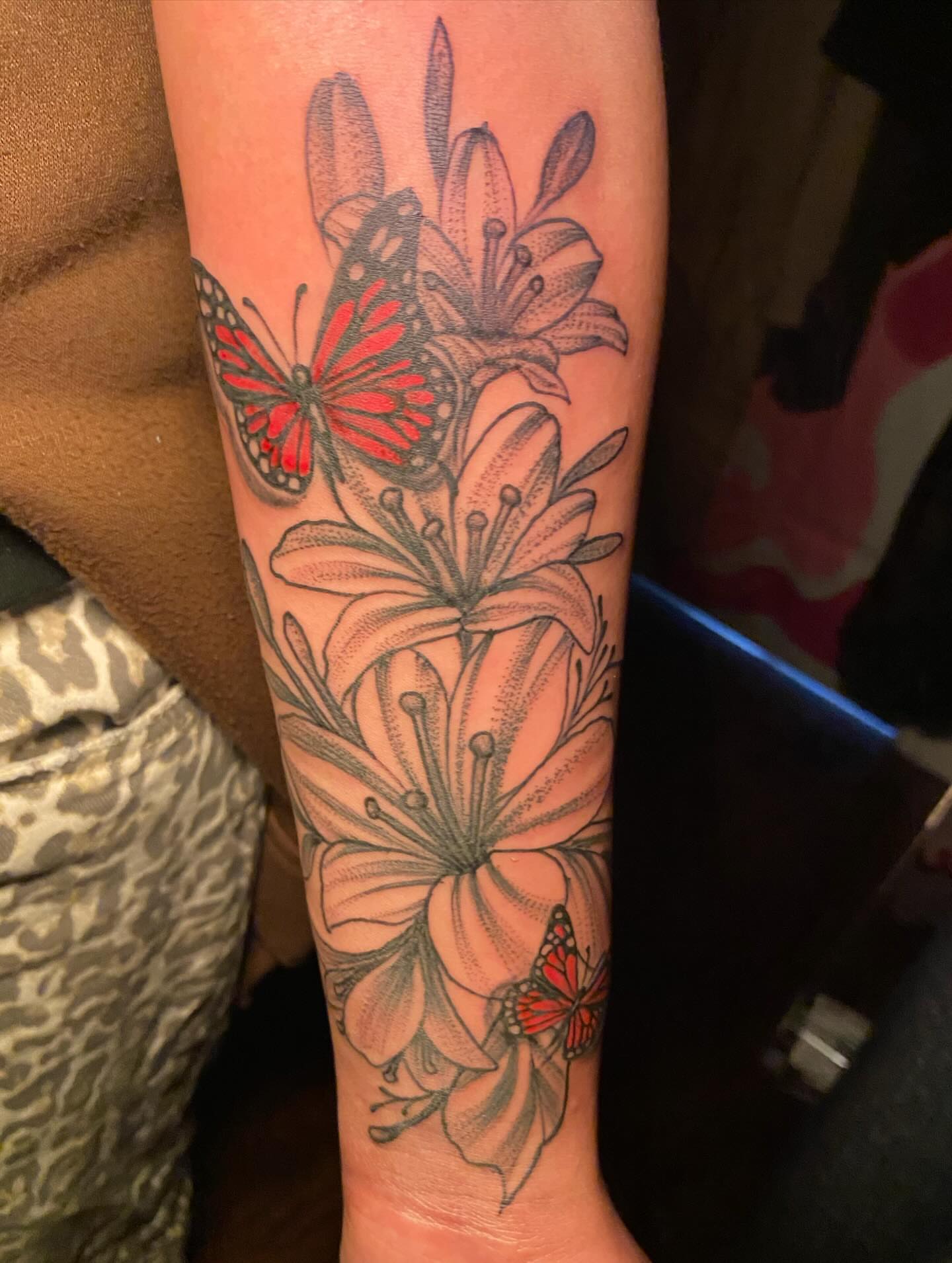 Lilies and butterflies dotwork tattoo on the forearm by Darius Armour (Tattoo Artist)