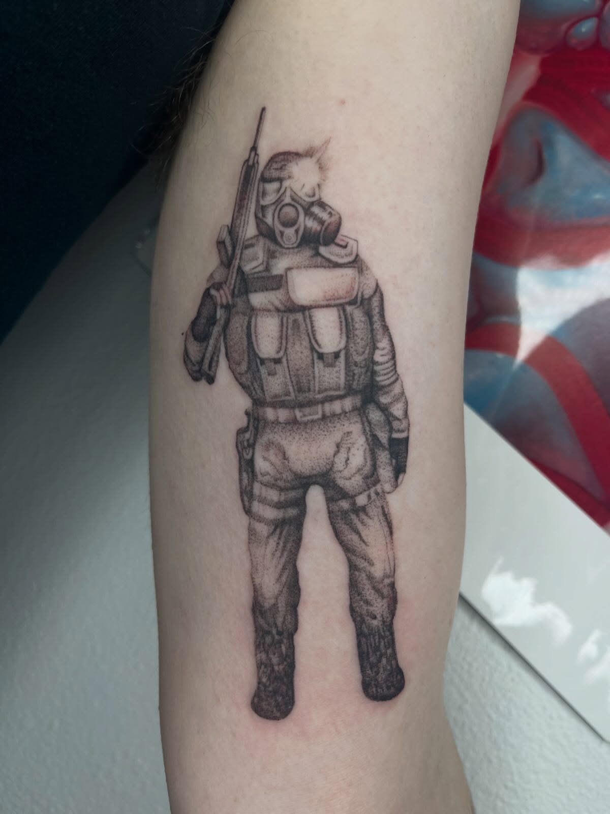 Soldier in gas mask dotwork tattoo on the forearm by Gabbie