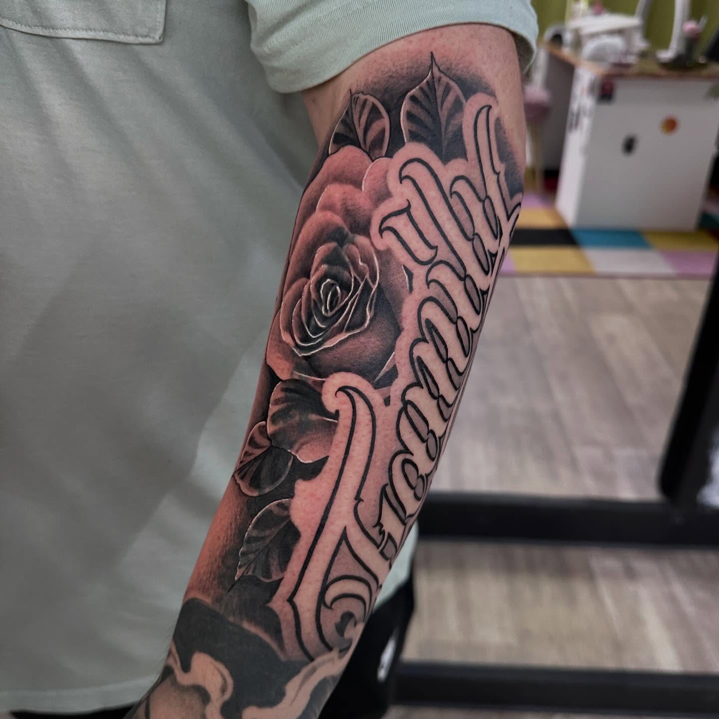 Rose and cursive text realism tattoo on the forearm by Dustin Clark, Dayton, Ohio