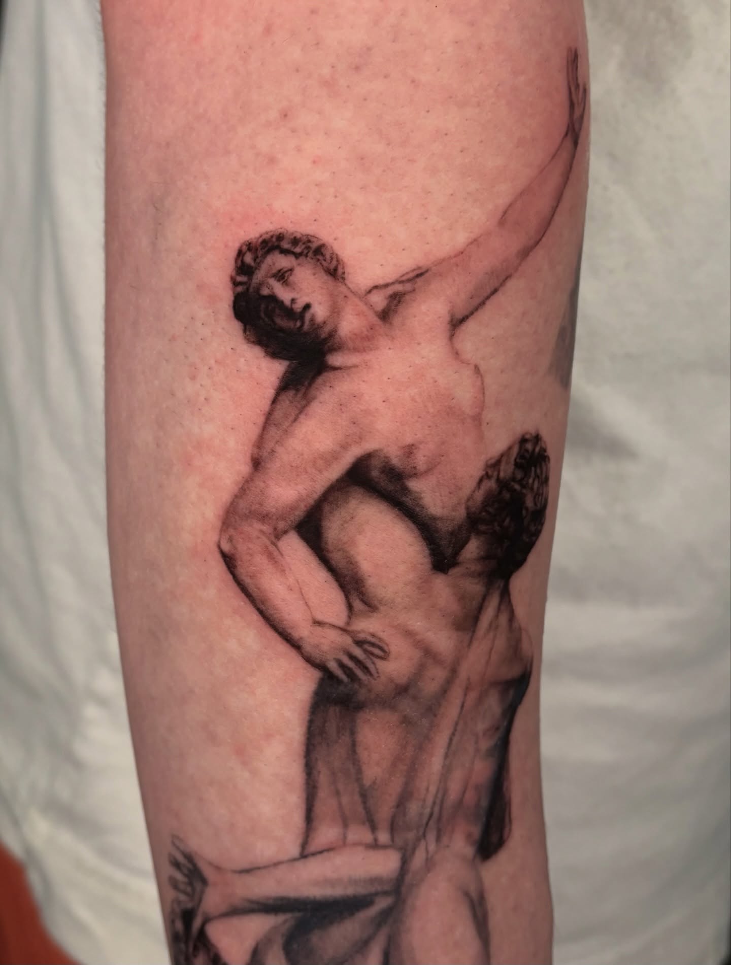 Cherub black and grey tattoo on the forearm by jordy