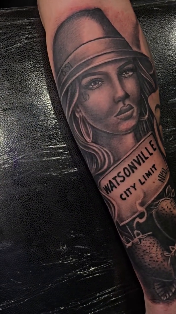 Woman with hat and banner realism tattoo by Richie Garcia, Hesperia, California