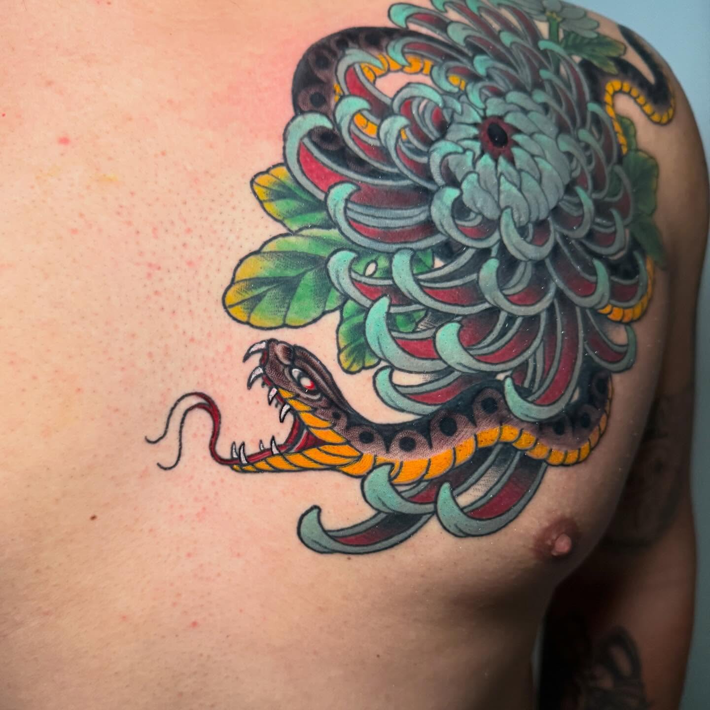 Snake and chrysanthemum American traditional tattoo on the shoulder by Zac Chaffin