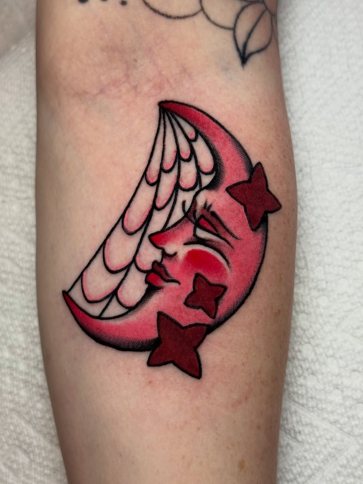 Winged crescent moon with stars American traditional tattoo on the forearm by Ash Nicola, Asheville, North Carolina