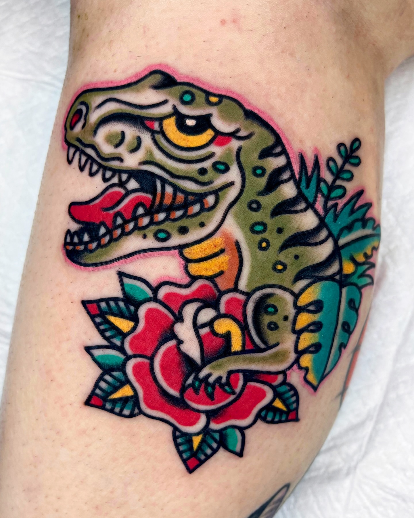 Dinosaur and rose American traditional tattoo on the forearm by 올드스쿨타투 레드립