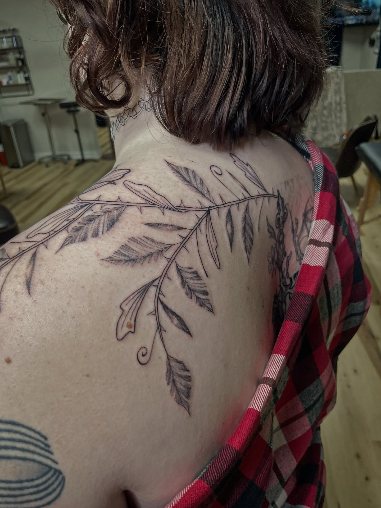 Leafy branch black and grey tattoo on the shoulder by Francesca Siwa