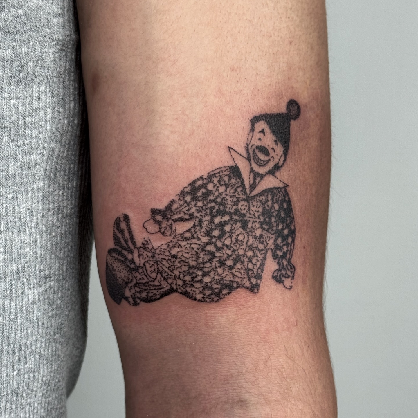 Clown black and grey tattoo on the forearm by Joint Killer