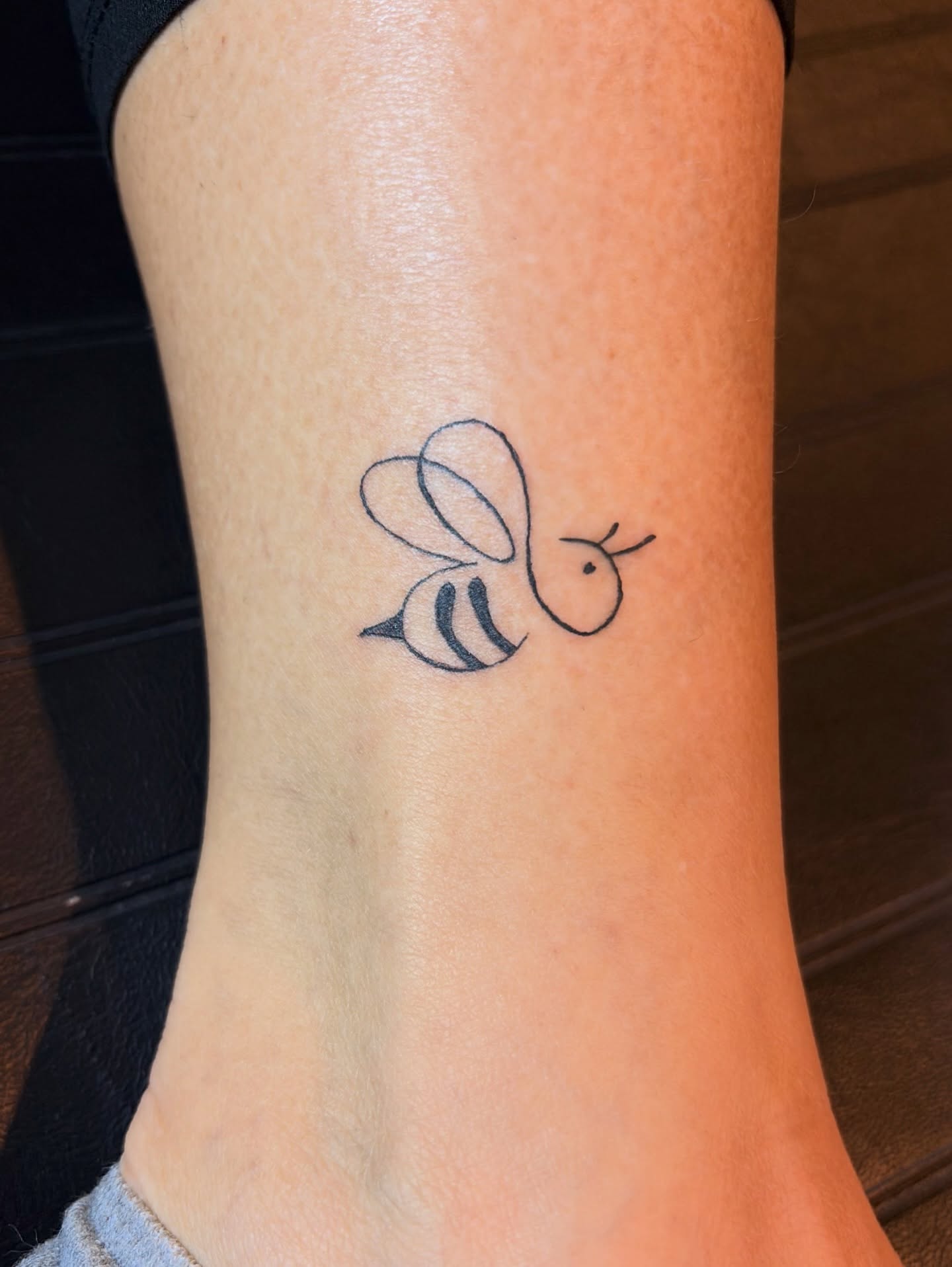 Bee minimalist tattoo on the forearm by Inky Birdz Tattoos