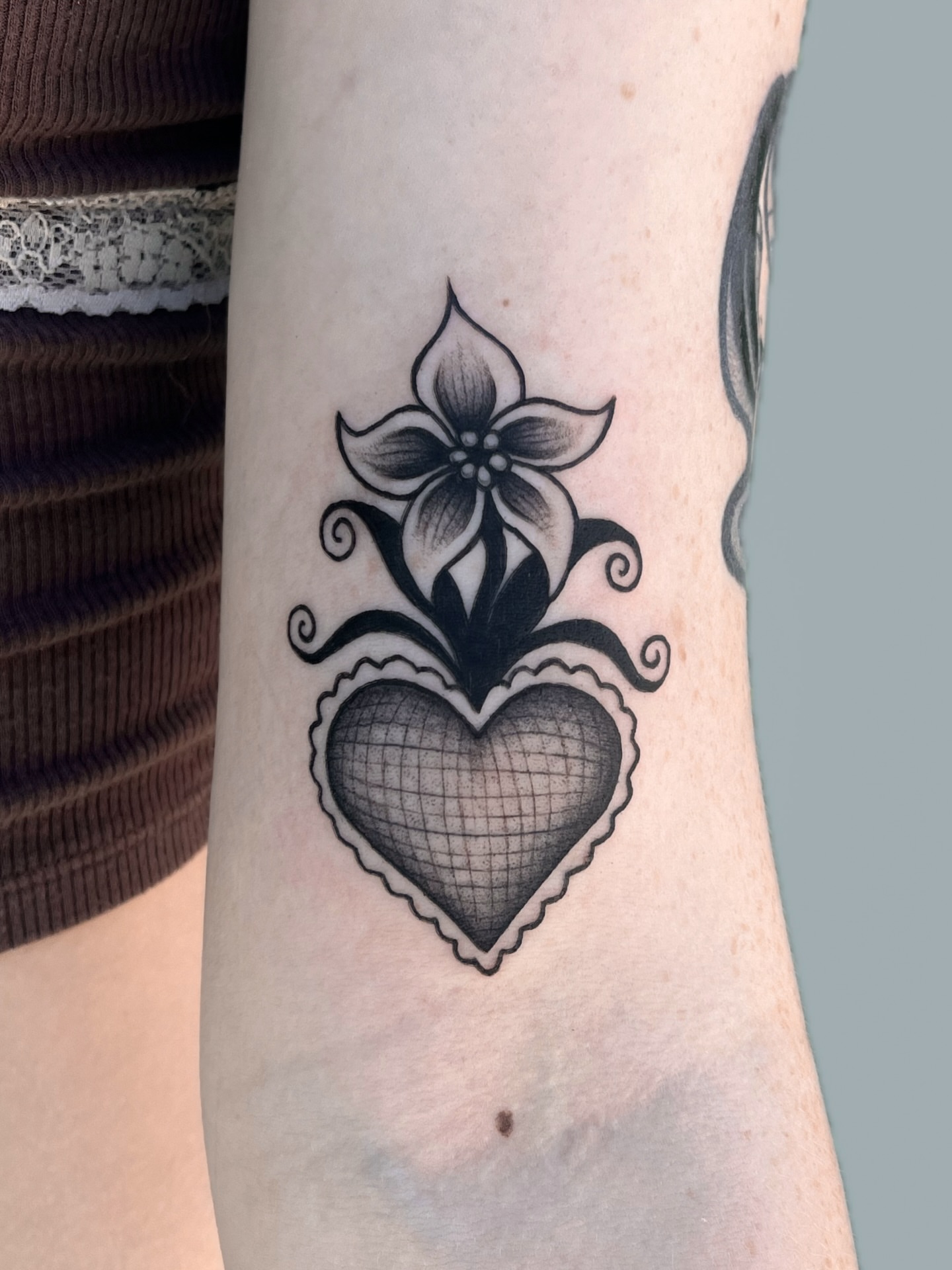 Heart with flower black and grey tattoo on the forearm by nina