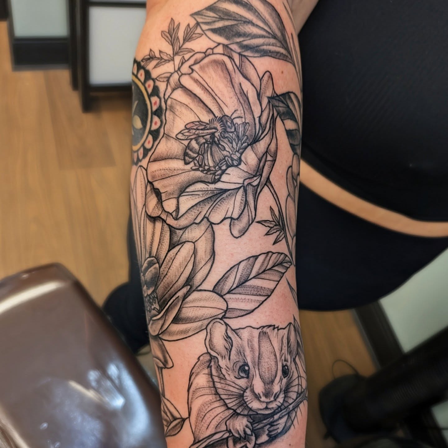 Flower and bee realism tattoo on the forearm by Devon Ward, Portland, Oregon
