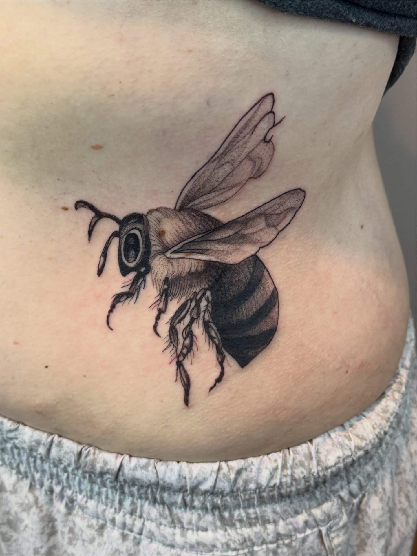 Bee realism tattoo on the ribs by Erick Mendivil