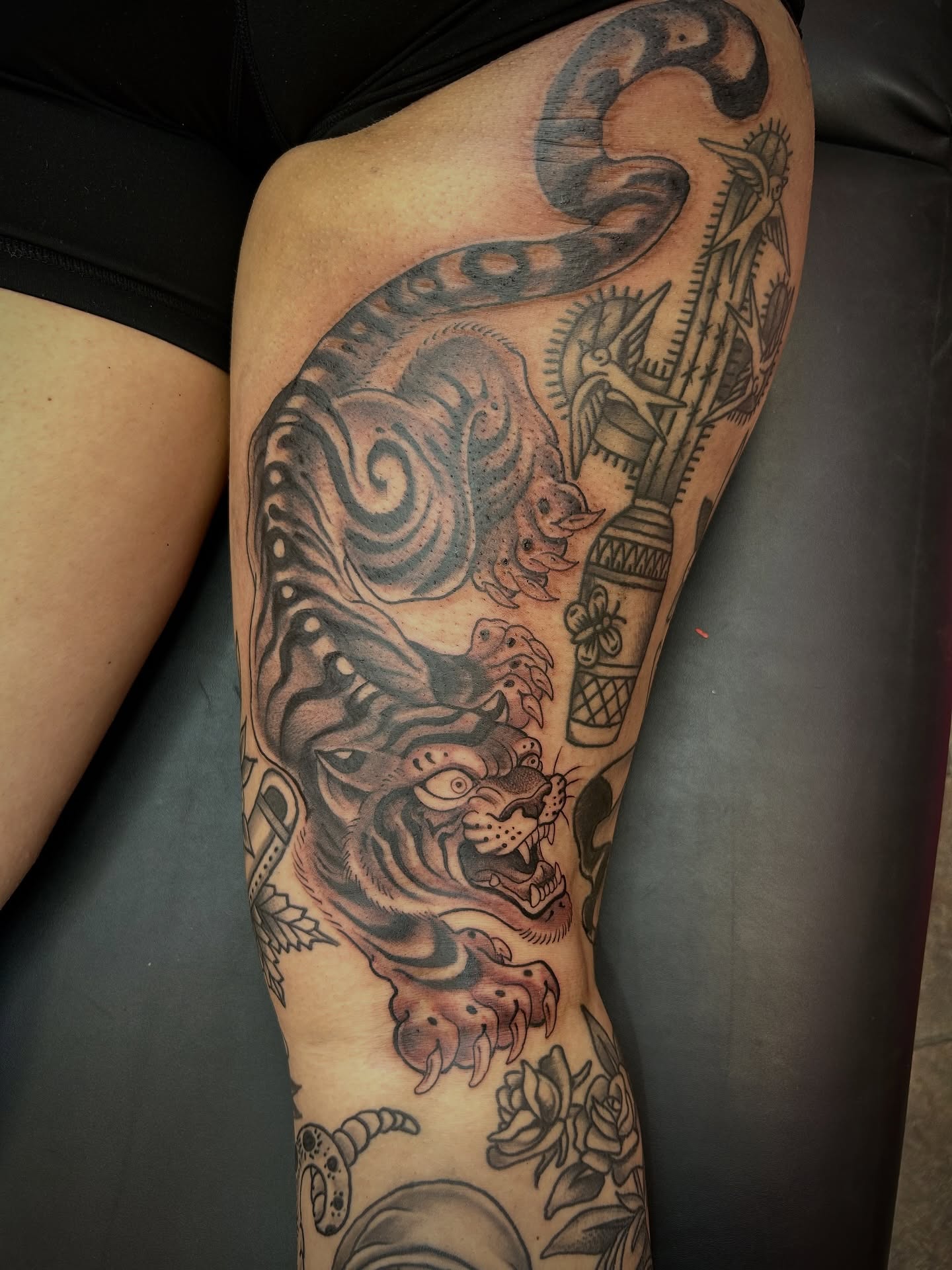 Tiger and snake American traditional tattoo on the thigh by Ryan Willard, Denver, Colorado