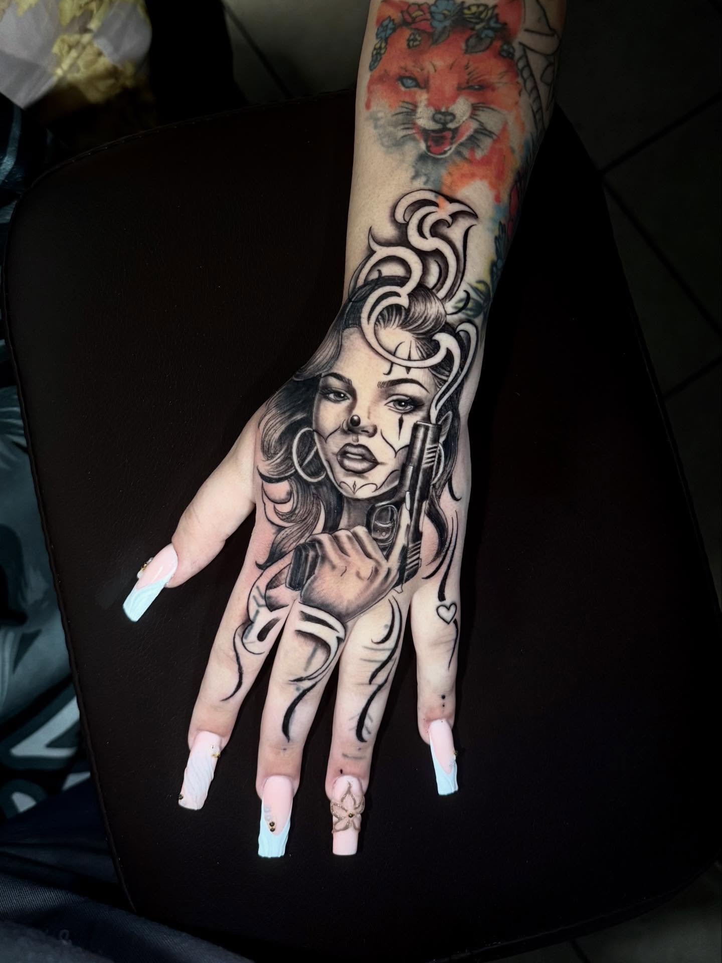 Woman with gun American traditional tattoo on the hand by Stilow Memphis Tattoo Artist, Memphis, Tennessee