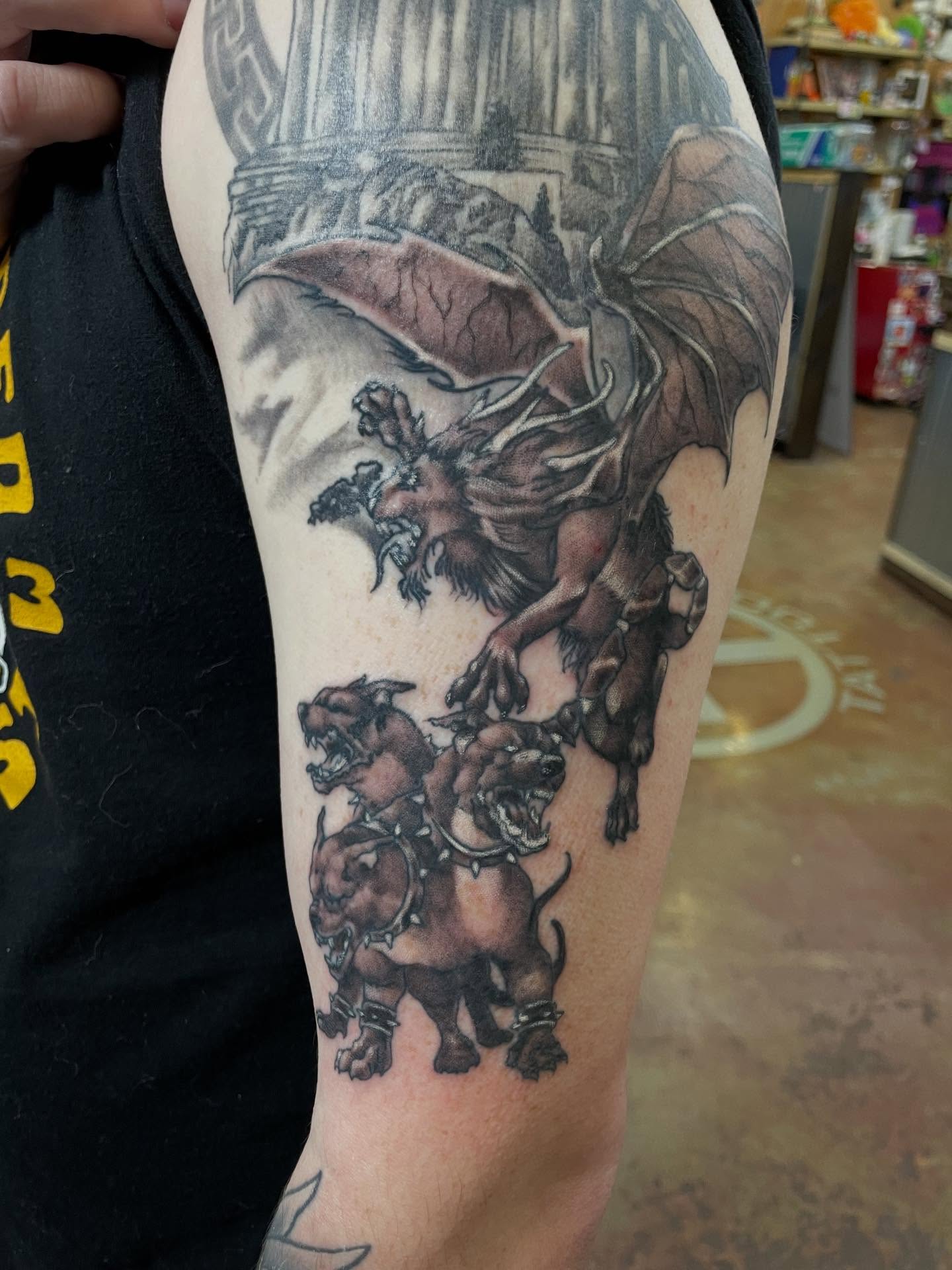 Mythical creature and dogs realism tattoo on the forearm by Heather Freitag